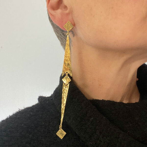 Longue boucle d'oreilles en forme de flèche.